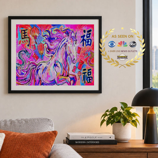 A framed colorful art print featuring a stylized horse with Chinese characters, displayed on a beige wall above a sofa in a living room setting. The artwork has a black frame and a gold 'AS SEEN ON' badge overlay on the right.