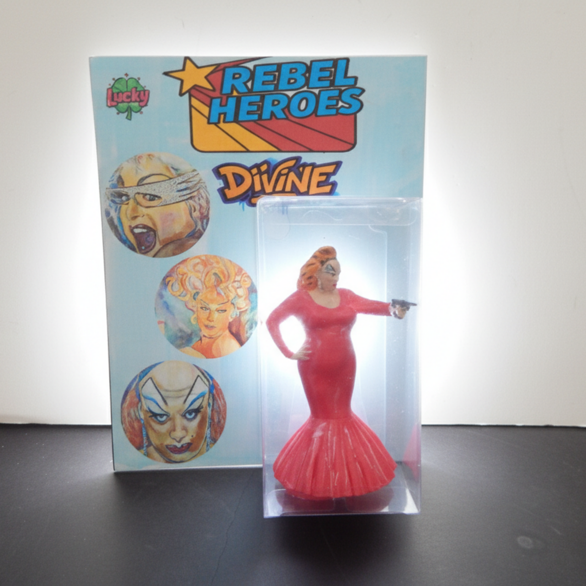 Pink figurine in a clear display case with 'Rebel Heroes Divine' packaging on a white background